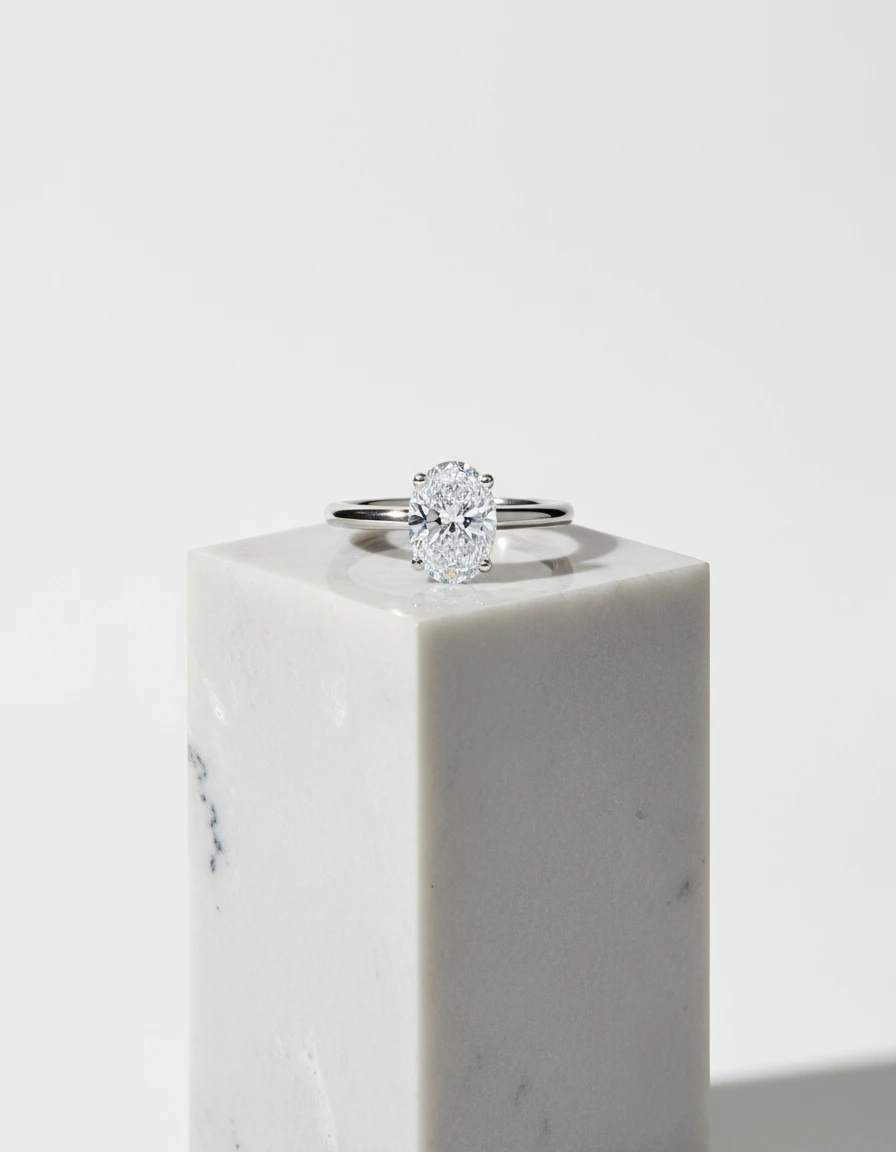 Impresionante anillo de diamante ovalado y claridad impecable flawless. El anillo reposa sobre una superficie de mármol que realza su belleza